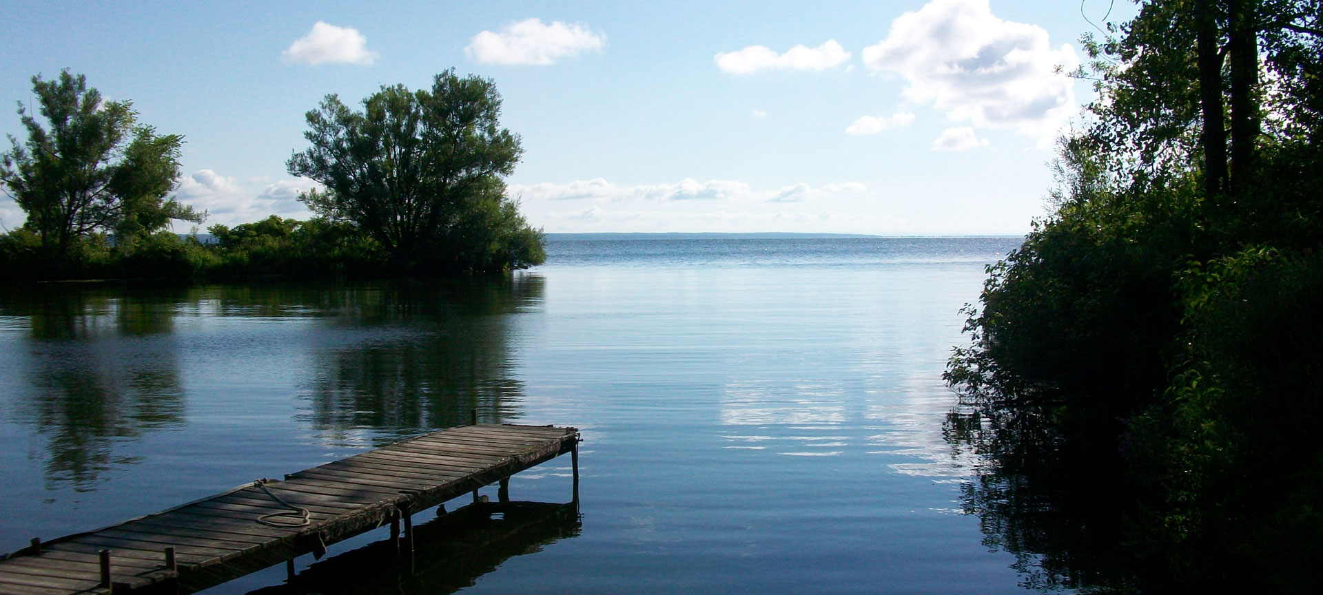 Shackel point dock over looking Oneida Lake with trees on each side